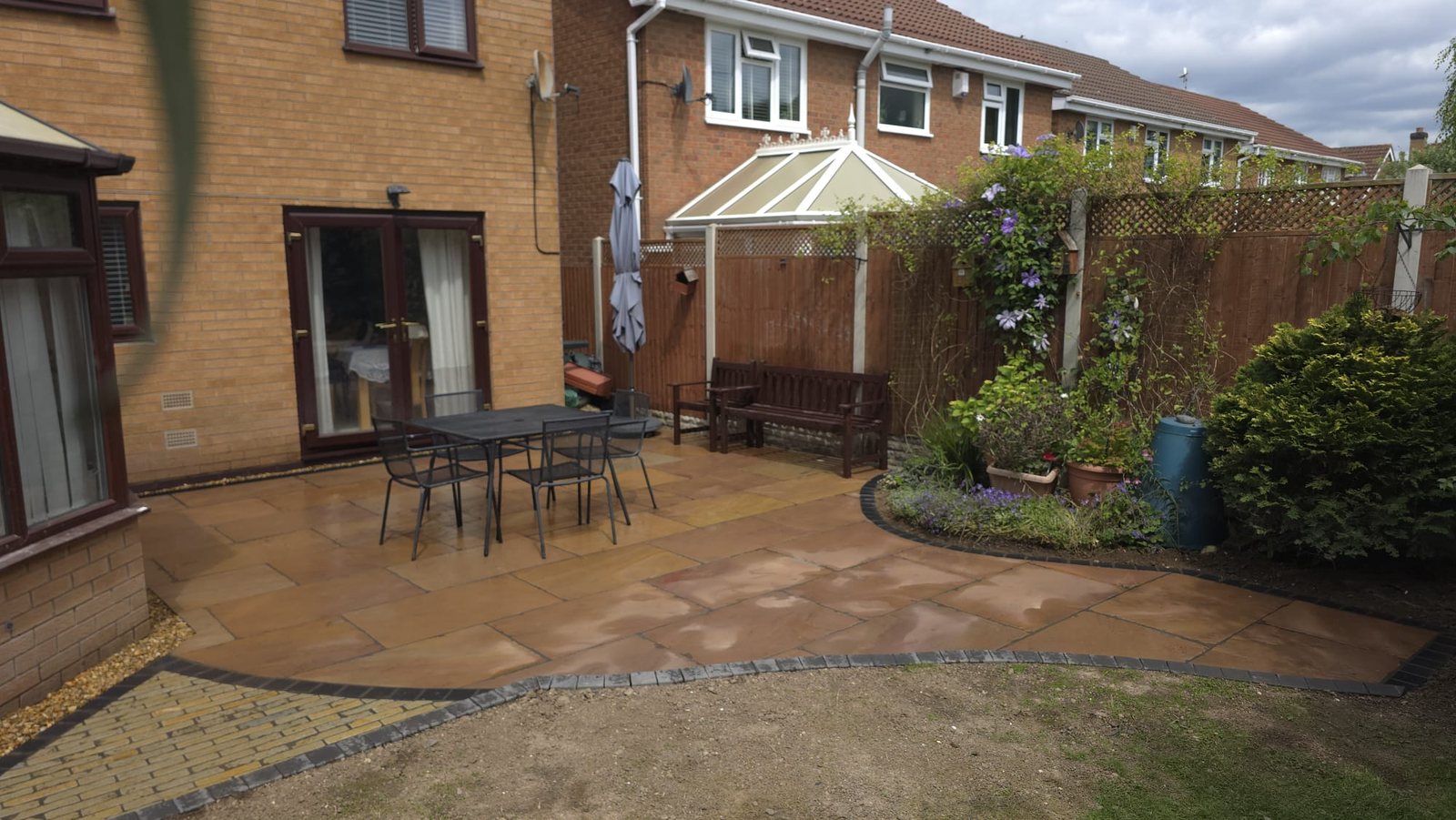 Indian sandstone patio, setts path and new garden fencing by Riverside Fencing Contractors